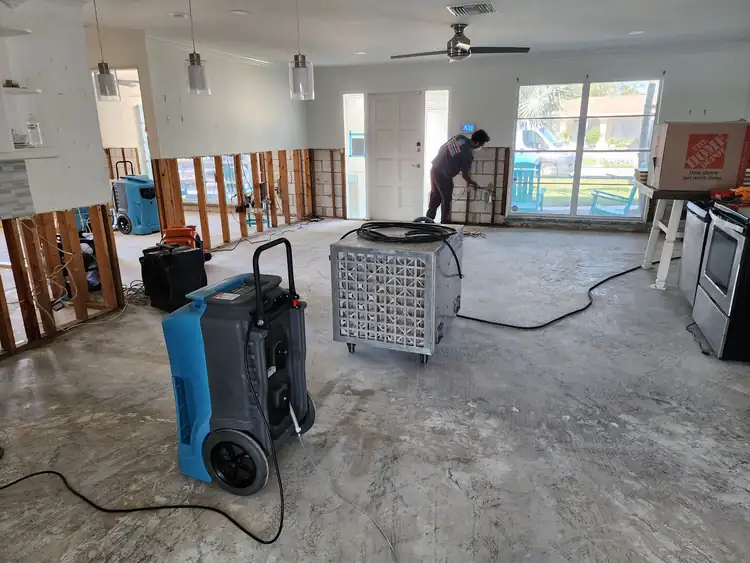 AquaSeekers technician and drying equipment in a home undergoing restoration
